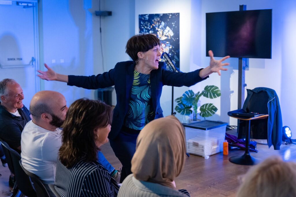 Actrice speelt een herkenbaar type tijdens een studiedag, met het publiek vlak voor haar